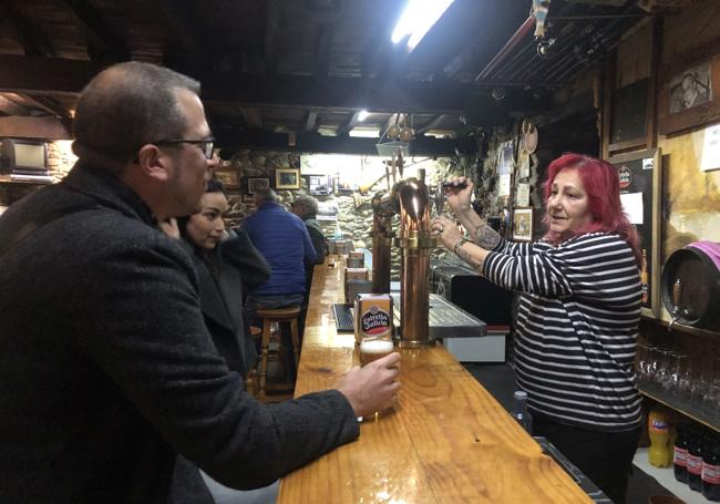 Ana Rodríguez sirve una caña a unos clientes en la bodega de El Pescador.