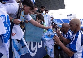 Dely Valdés and Darío Silva sign shirts.
